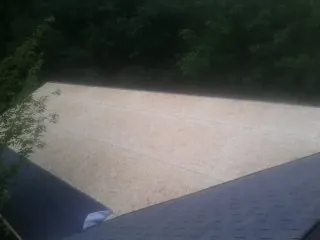 New OSB roof sheathing installed beside an existing shingle roof in Ramseur