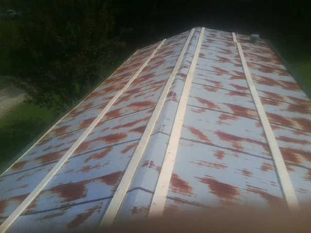 Rusted metal roof panels with new wood purlins before replacement — Storm Damage Roof Repair in Ramseur by Roofing Brothers