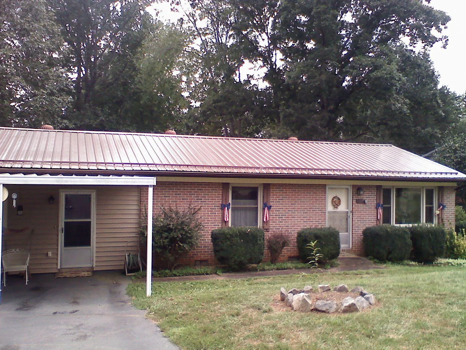 Bronze metal roof and carport on a brick ranch home — Roof Repair work by our crew in Ramseur