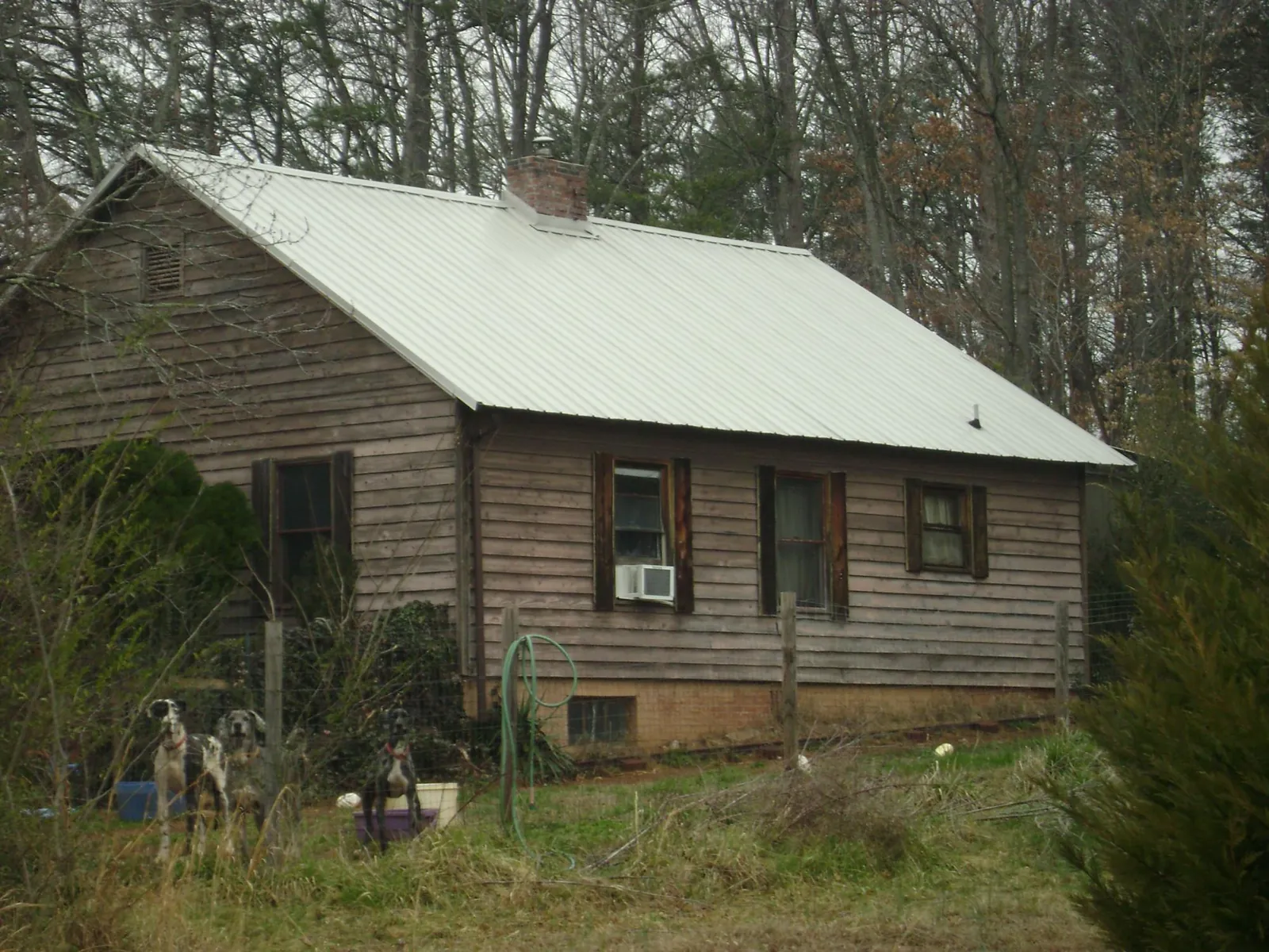 White metal roof on an old wood sided farmhouse, from a Metal Roof Installation job in Ramseur
